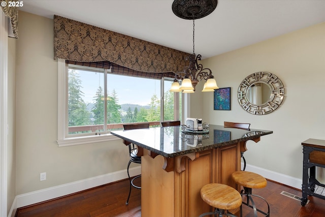 dining room with dark wood finished floors, baseboards, and a chandelier