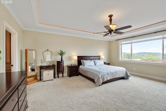bedroom featuring crown molding, carpet flooring, baseboards, a raised ceiling, and a ceiling fan