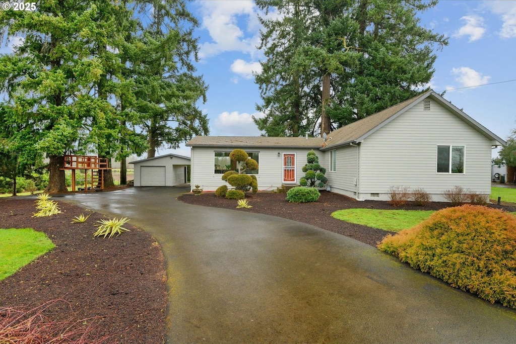 ranch-style house with a garage, an outbuilding, crawl space, and driveway