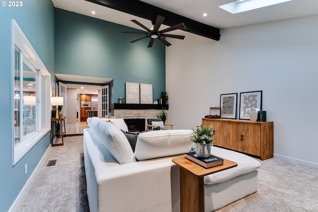 2915 Chuckanut St, Eugene, OR 97408 - carpeted living area featuring a fireplace, beamed ceiling, a skylight, ceiling fan, and high vaulted ceiling