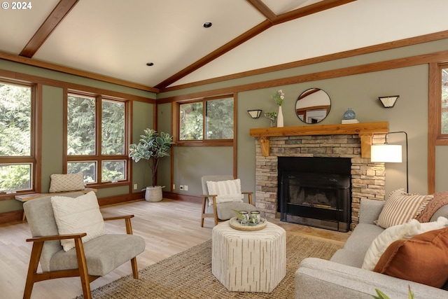 living room featuring light wood-style floors, a stone fireplace, a healthy amount of sunlight, and lofted ceiling with beams