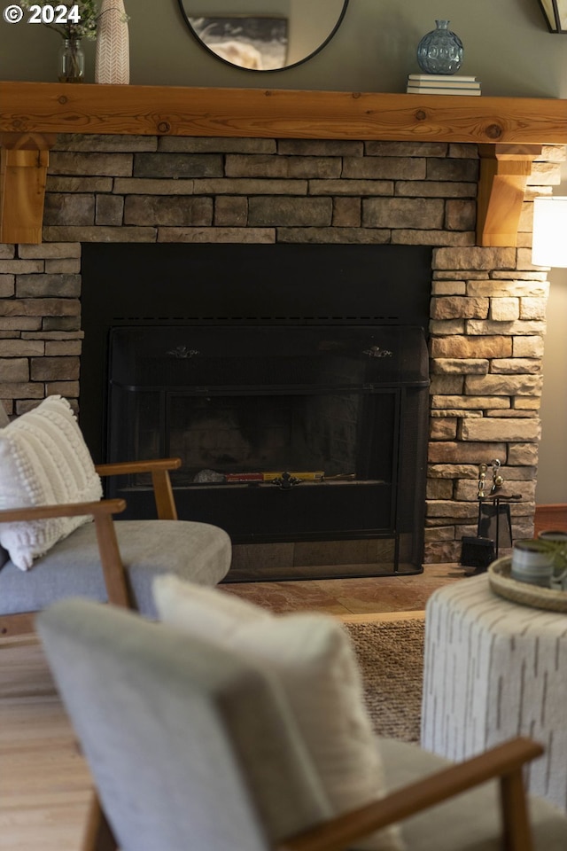 room details with a stone fireplace and wood finished floors