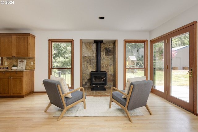 sitting room featuring a wood stove and light wood-type flooring