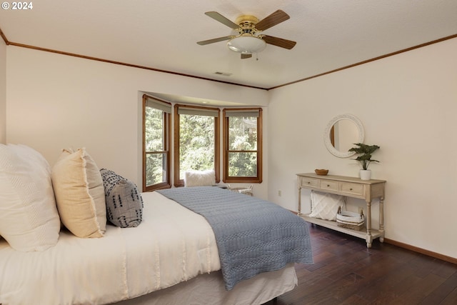 bedroom with crown molding, visible vents, dark wood finished floors, and baseboards