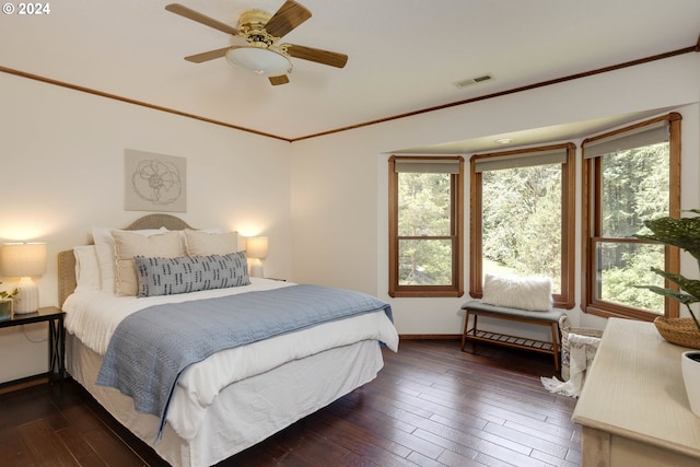 bedroom featuring ceiling fan, dark wood-style flooring, visible vents, baseboards, and crown molding