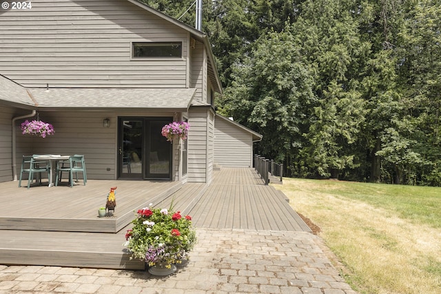 wooden terrace with outdoor dining area and a yard