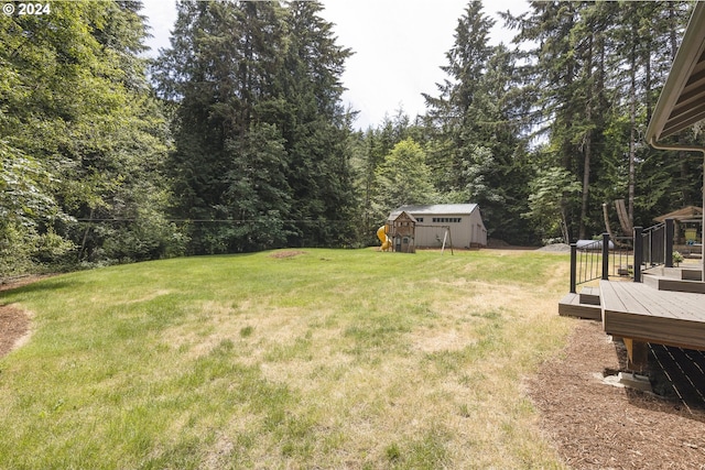 view of yard featuring a deck, a shed, and an outbuilding