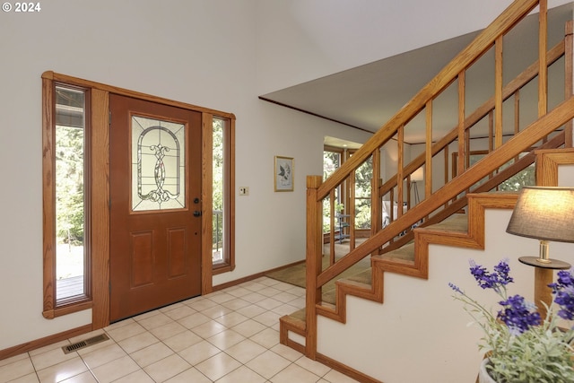 foyer entrance featuring light tile patterned floors, visible vents, and a wealth of natural light