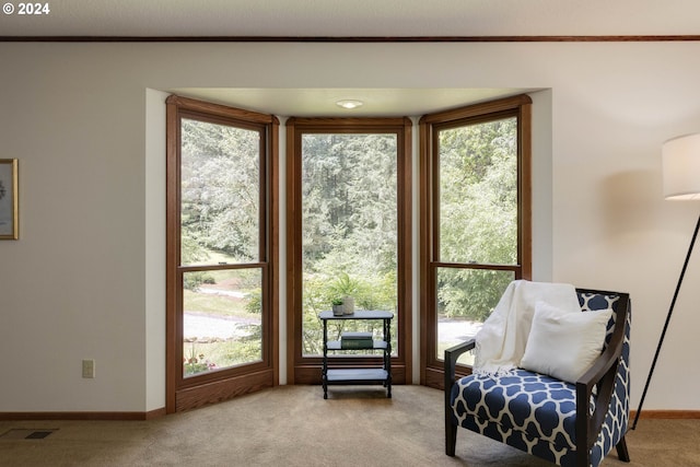 sitting room featuring baseboards, visible vents, and light colored carpet