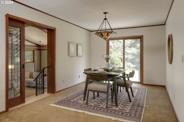 dining area featuring light carpet, baseboards, and crown molding