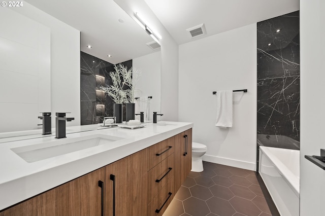 bathroom with a tub to relax in, tile patterned floors, vanity, and toilet