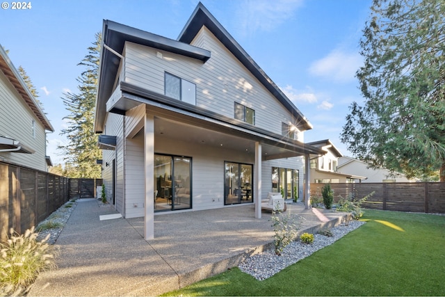 rear view of property with a patio area and a lawn