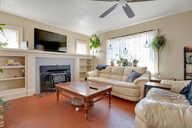 living room featuring ceiling fan, a wood stove, a fireplace, and built in features