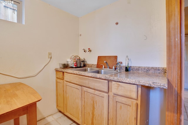 kitchen featuring light brown cabinets, sink, and light tile floors