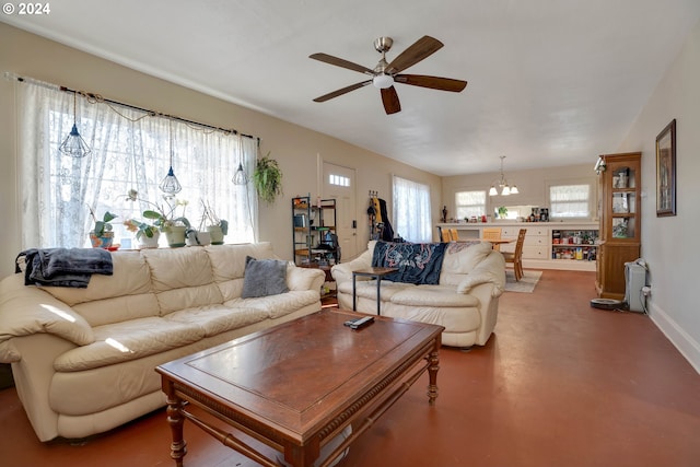 living room featuring ceiling fan with notable chandelier