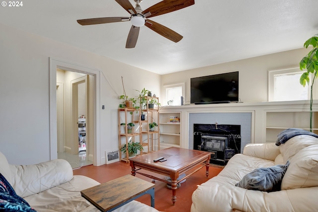 living room with light hardwood / wood-style flooring, ceiling fan, and a brick fireplace