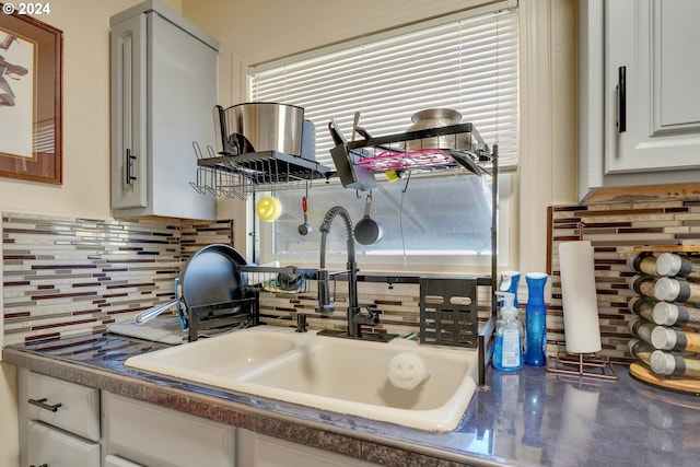 kitchen with tasteful backsplash, sink, white cabinetry, and a wealth of natural light