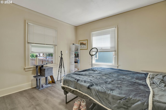 bedroom featuring crown molding and light hardwood / wood-style floors