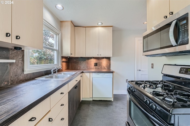 kitchen with cream cabinetry, sink, tasteful backsplash, and stainless steel appliances