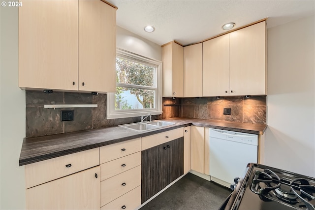 kitchen featuring tasteful backsplash, cream cabinets, stove, white dishwasher, and sink