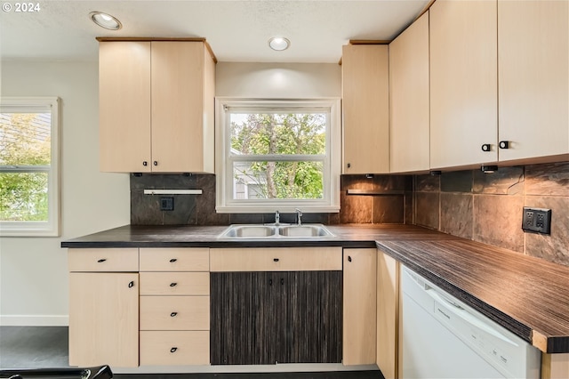 kitchen with sink, cream cabinets, backsplash, and white dishwasher