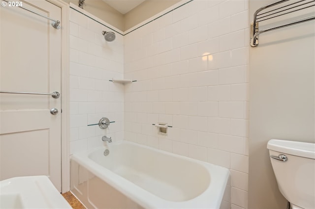 bathroom featuring toilet and tiled shower / bath combo