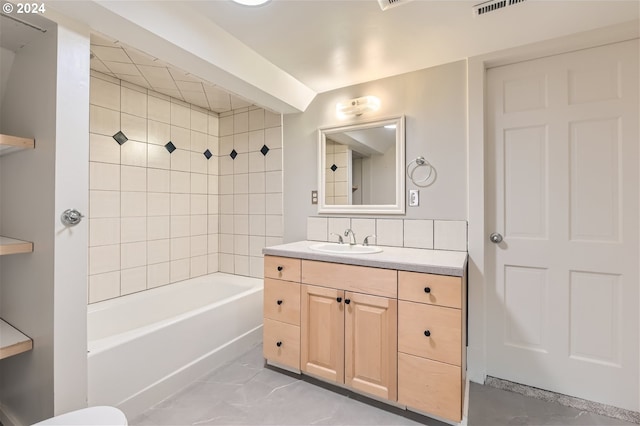 bathroom with tile floors, tiled shower / bath combo, and large vanity