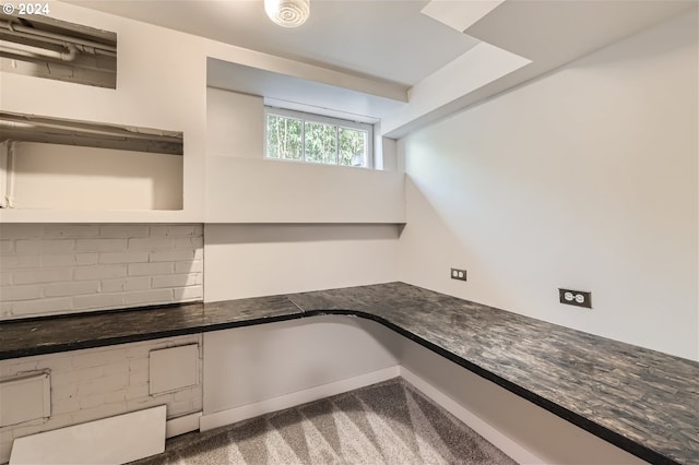 interior space featuring backsplash and carpet