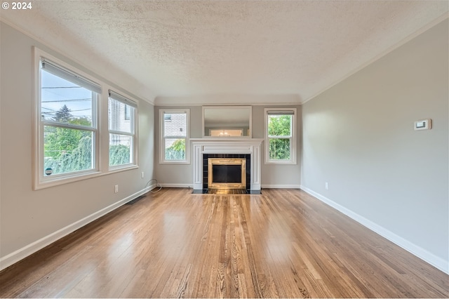 unfurnished living room with a textured ceiling, a fireplace, and wood-type flooring