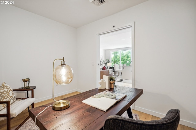 office featuring light wood-type flooring, visible vents, and baseboards