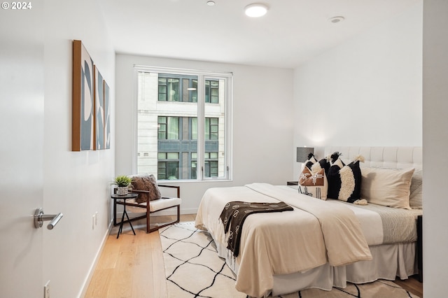 bedroom featuring light wood finished floors and baseboards