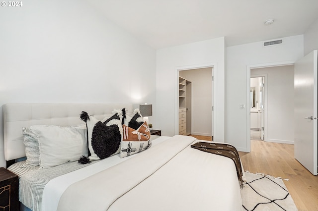 bedroom with light wood-style flooring, baseboards, and visible vents