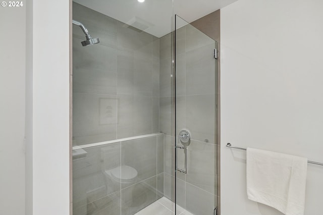 bathroom featuring toilet and a stall shower