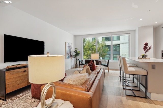 living area with recessed lighting, baseboards, and light wood finished floors