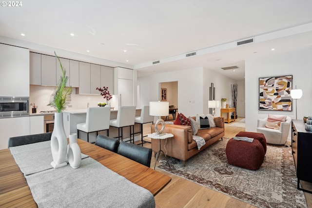 living area with visible vents, recessed lighting, and light wood-style floors