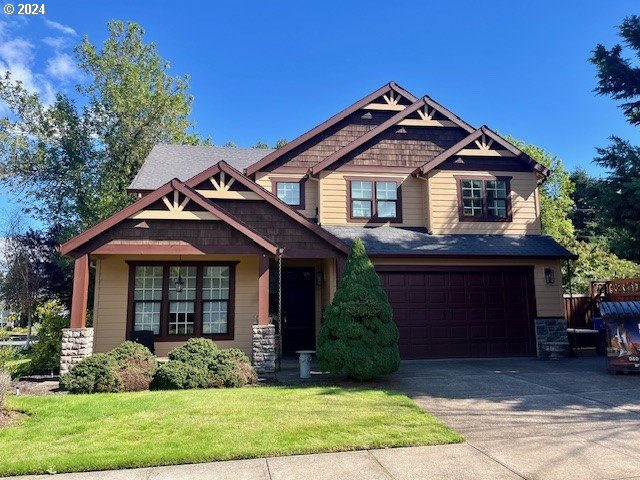 craftsman house with a front yard and a garage