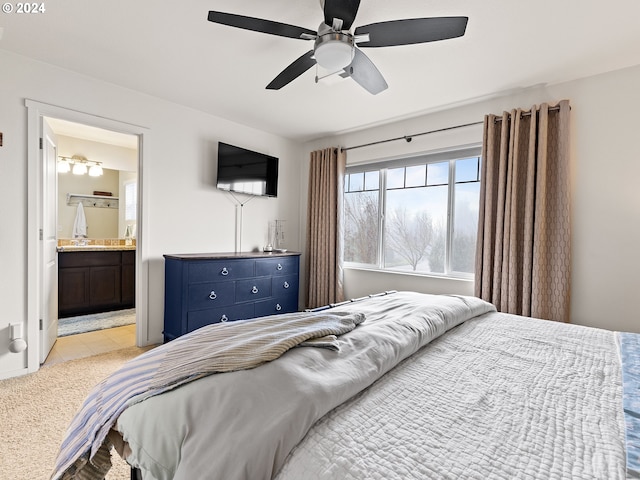 bedroom featuring ceiling fan, ensuite bathroom, and light carpet