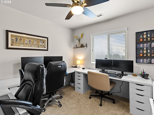 carpeted home office featuring ceiling fan