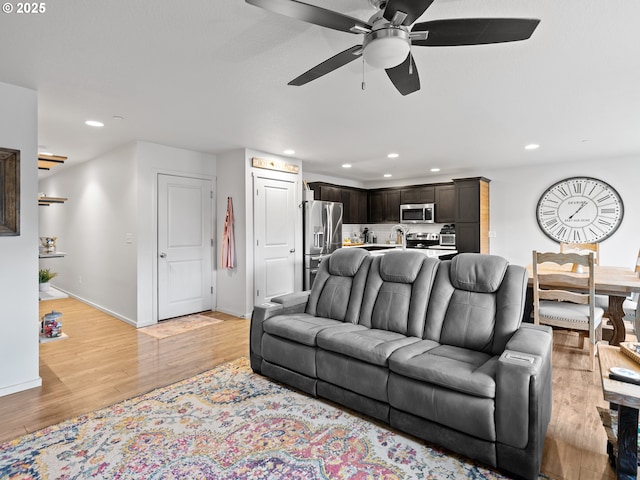 living room with ceiling fan and light wood-type flooring