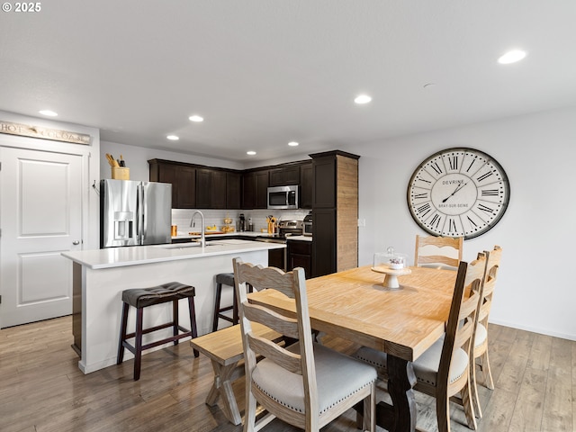 dining space with sink and light hardwood / wood-style flooring