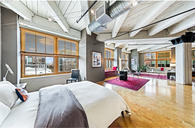 bedroom with lofted ceiling with beams and hardwood / wood-style flooring