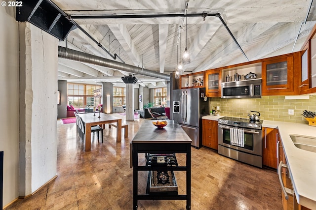 kitchen with vaulted ceiling, appliances with stainless steel finishes, sink, and tasteful backsplash