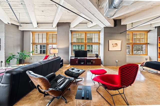 living room featuring concrete floors, beamed ceiling, and a wealth of natural light