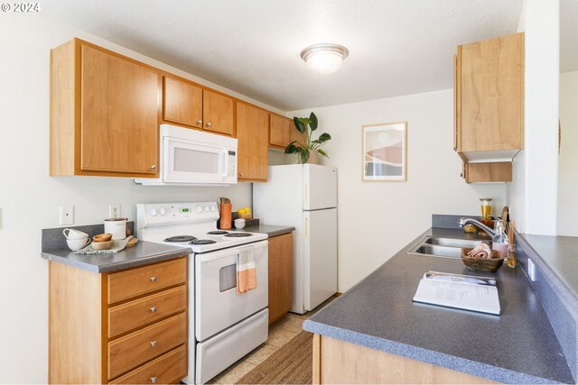 kitchen featuring white appliances, sink, and light tile patterned floors