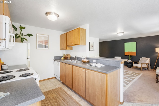 kitchen featuring white appliances, baseboards, open floor plan, a peninsula, and a sink