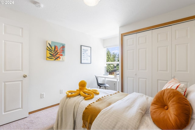 bedroom featuring a textured ceiling, a closet, carpet, and baseboards