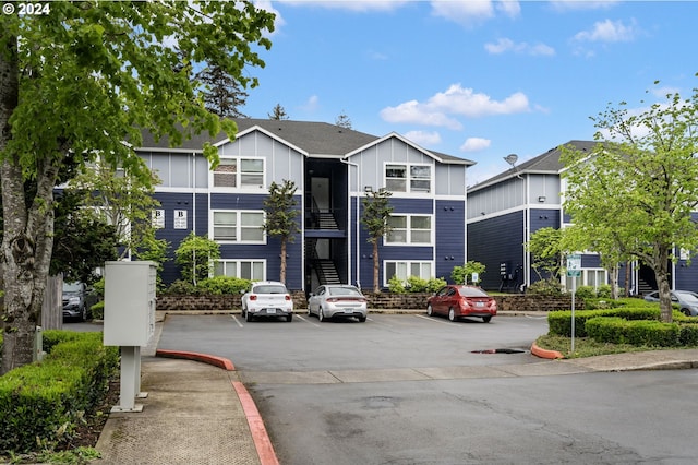 view of building exterior featuring a residential view and uncovered parking