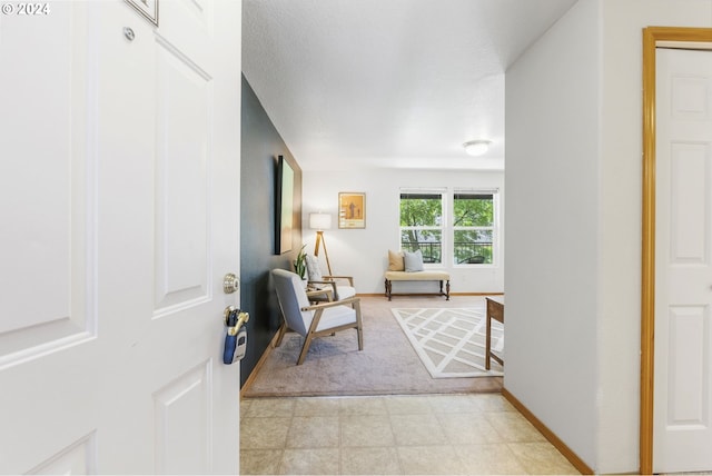 living area featuring light floors and baseboards