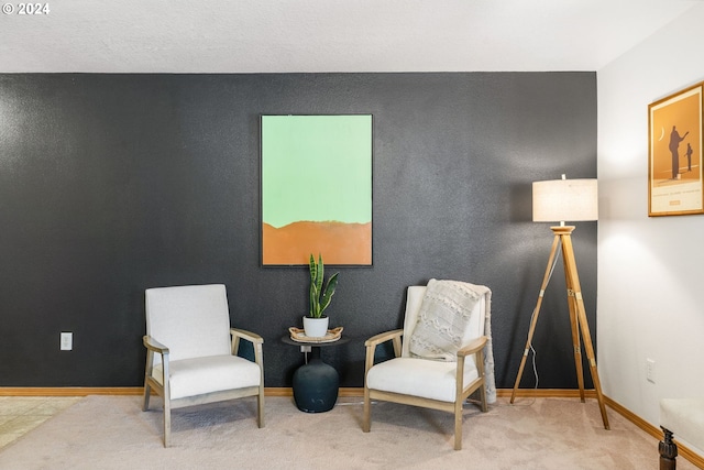 sitting room featuring carpet flooring and baseboards