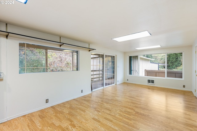 unfurnished room with a wealth of natural light and light hardwood / wood-style floors